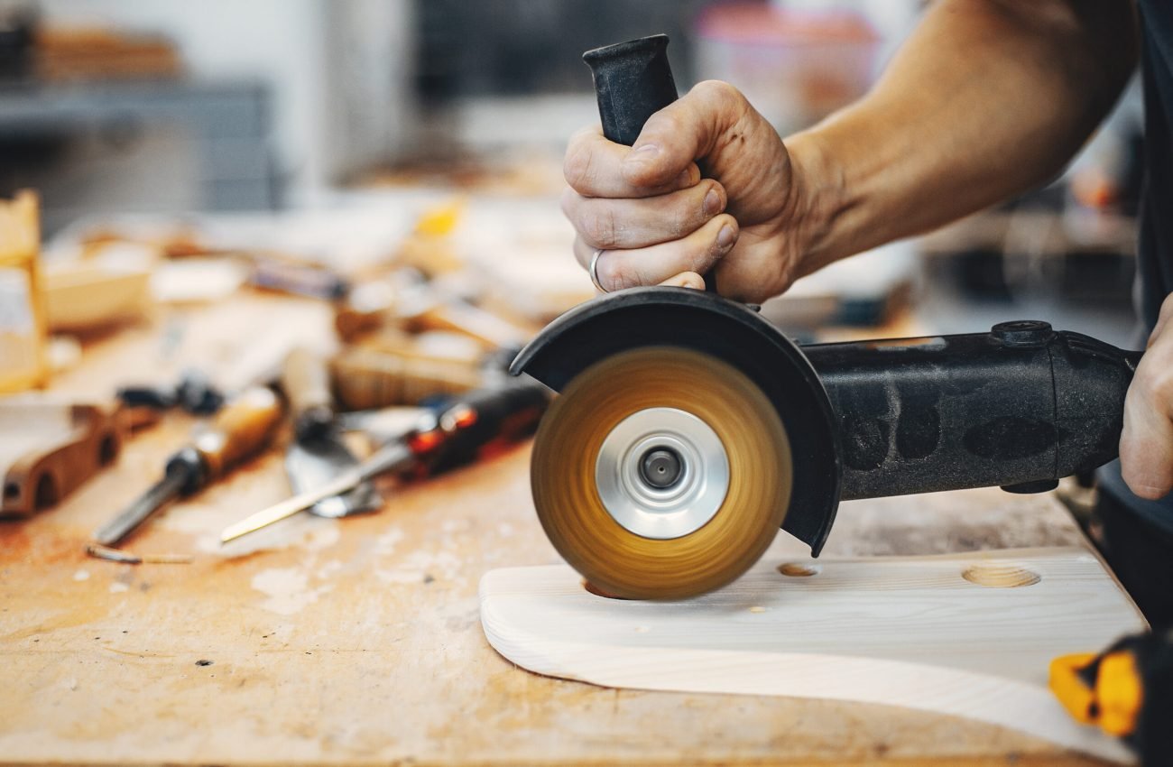 A man carves a tree. The carpenter works in a studio. An engineer provides a tree shape